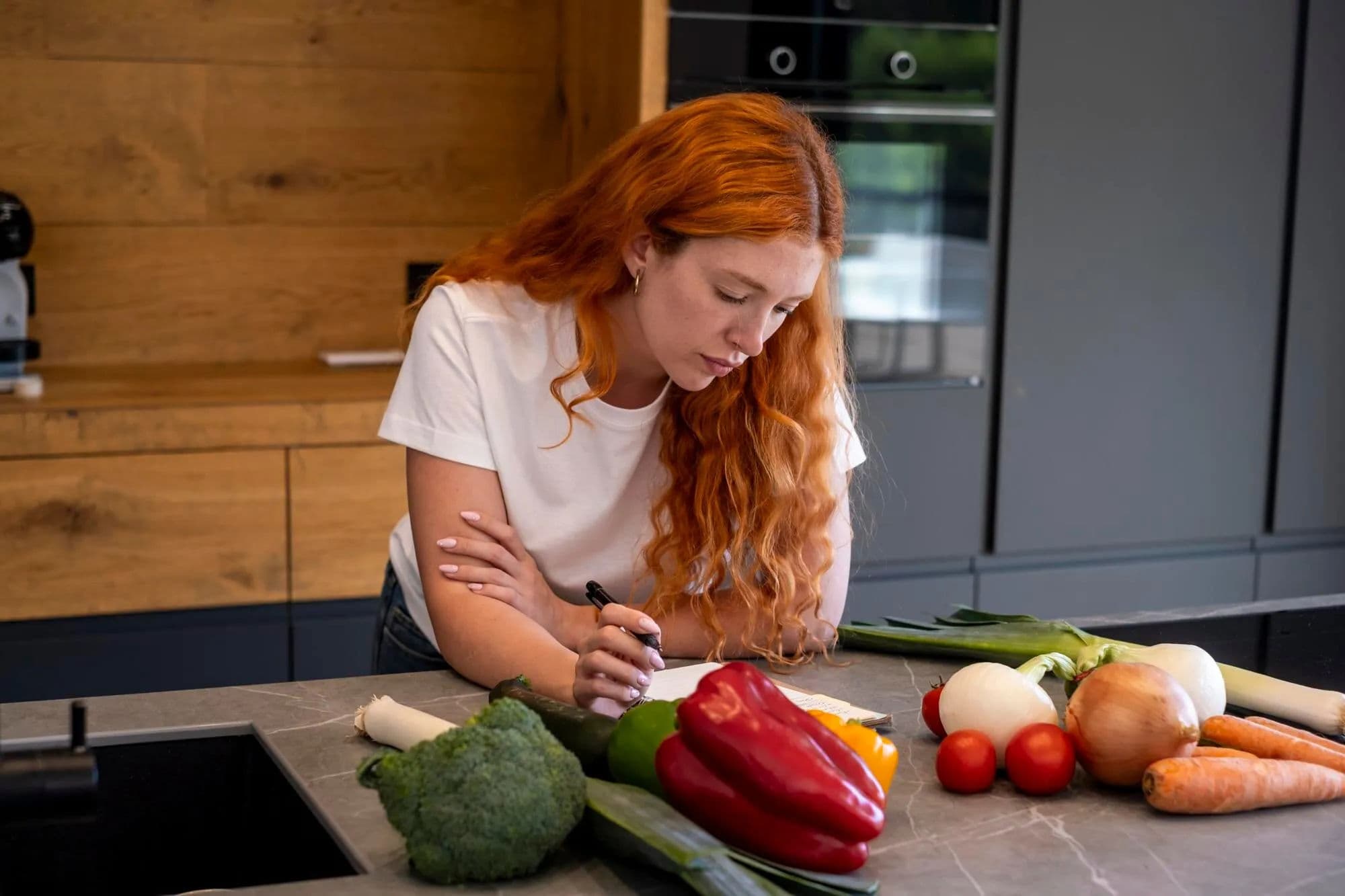 Cozinheira reunindo ingredientes de várias receitas em uma lista de compras
