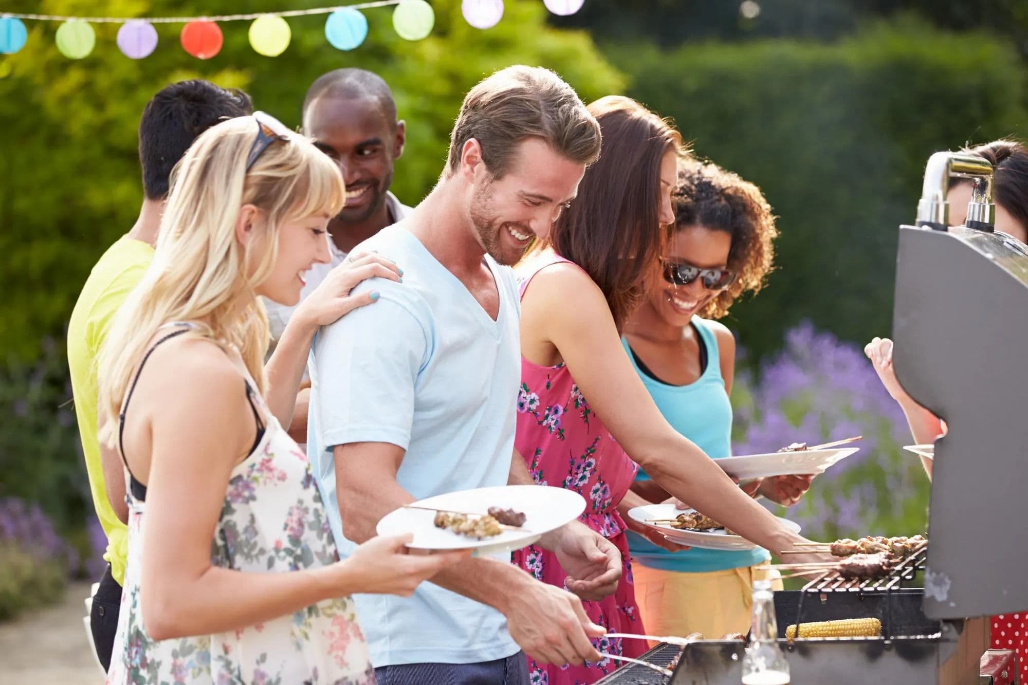 Friends serving food at a relaxed backyard party